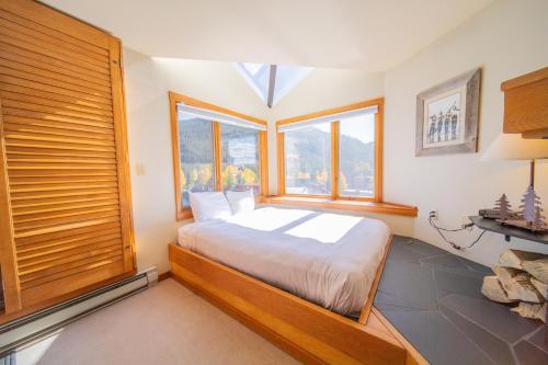 ein Schlafzimmer mit einem Bett und einem großen Fenster in der Unterkunft Lakeside 1495 in Keystone