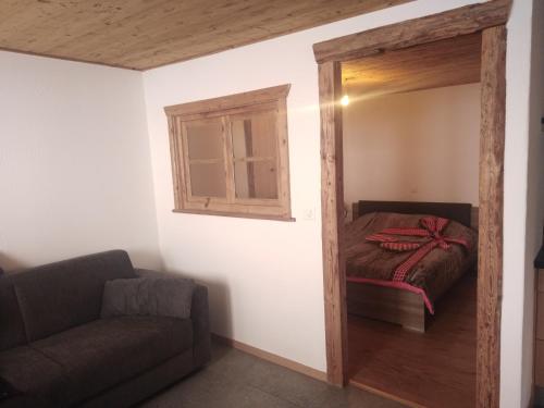 um quarto com uma cama, um sofá e um espelho em Appartement proche Villars em Panex