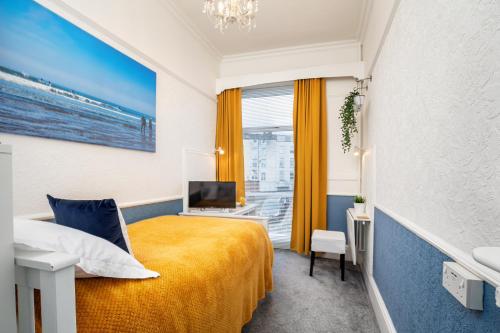 a hotel room with a yellow bed and a window at Glenholme Guest House - Room Only in Scarborough