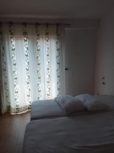 a bedroom with a bed and a large window at Appartamento Diana in Roccaraso
