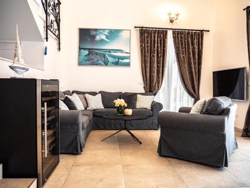 a living room with two couches and a tv at Elegant Hvar town villa with pool in Hvar