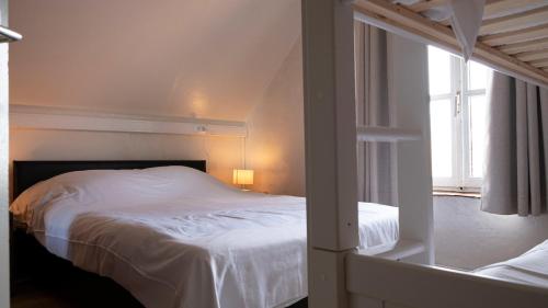 sypialnia z białym łóżkiem i oknem w obiekcie De Vitsemolenhoeve w mieście Westouter