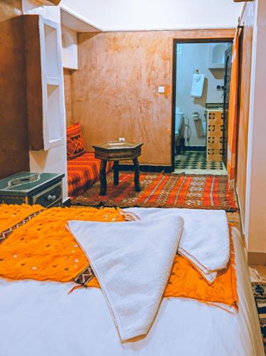 a bedroom with a bed and a table in it at Kasbah Assafar in Kalaat MGouna