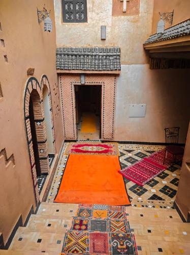 a room with an orange rug on a floor with carpets at Kasbah Assafar in Kalaat MGouna