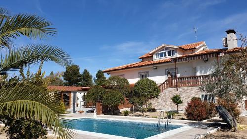 uma casa com piscina em frente a uma casa em Hacienda Cruz em Toledo
