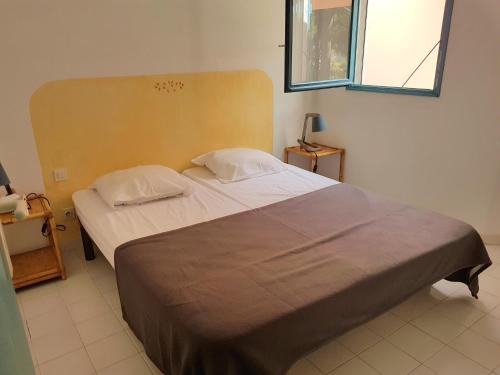 een slaapkamer met een groot bed met 2 kussens bij ST CYPRIEN D29 -4/5 pers- à 250m de la plage de sable Saint Cyprien in Lecci