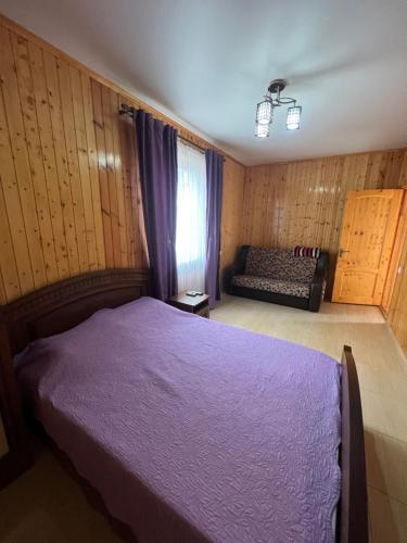 Ararat & Svetlana في Alakhadzi: غرفة نوم مع سرير أرجواني وأريكة