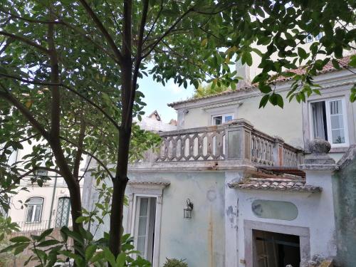 a white house with a balcony on top of it at OSBORNE GUEST HOUSE in Sintra