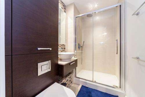 a bathroom with a shower and a toilet and a sink at Contemporary Top floor flat in Kentish Town in London