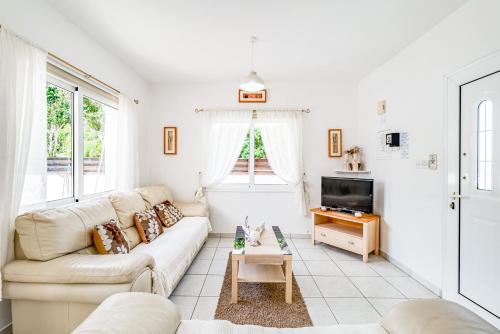 a living room with a couch and a table at Villa Sunnyside Mandali by Ezoria Villas in Protaras