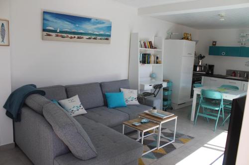 un salon avec un canapé gris et une table dans l'établissement Comme à la maison, à La Tranche-sur-Mer