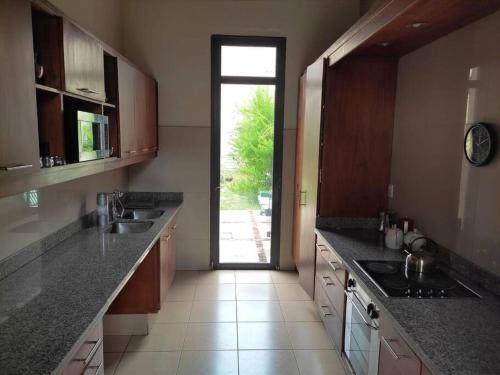 uma cozinha com um lavatório e uma porta para um quintal em Espectacular Casa !Inmejorable ubicación em Salto