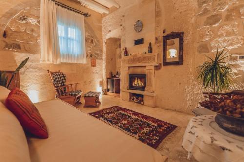 a bedroom with a bed and a fireplace at Peristyle Cave Cappadocia- Special Class in Uçhisar