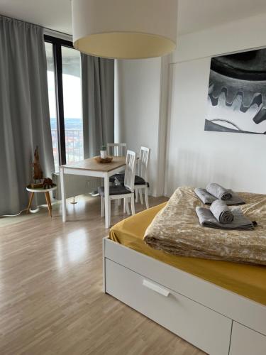 1 dormitorio con 1 cama y comedor con mesa en Cityapartment im 33. Stock, en Augsburg