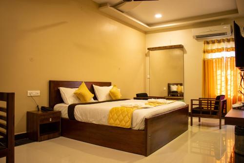 1 dormitorio con 1 cama grande con almohadas amarillas en Faiz Residency en Rāmanāthapuram