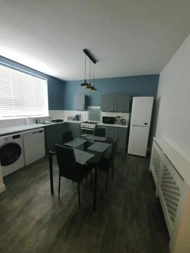 a kitchen with a table and chairs in a room at 1-Bedroom A Greater Manchester in Middleton