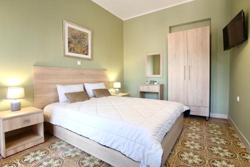 a bedroom with a large bed and a flat screen tv at GK Mediterranean Village - Airport Free Shuttle by GK Properties in Markopoulo