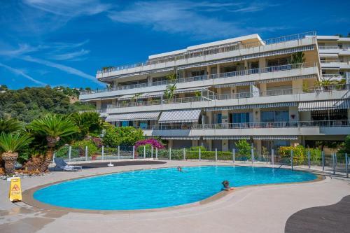 une personne dans une piscine en face d'un bâtiment dans l'établissement Studio Menton Garavan avec piscine à proximité Italie et Monaco, à Menton