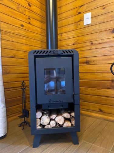 a wood stove with logs inside of a room at La Nostra Terra in Nova Veneza