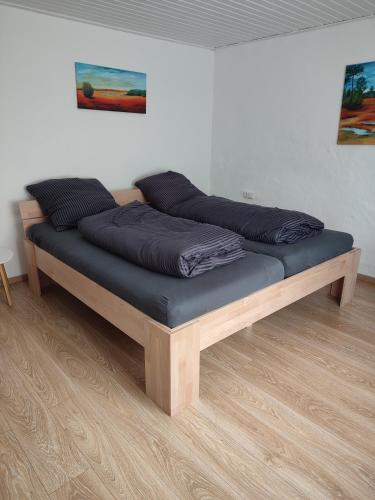 uma cama com almofadas azuis em cima num quarto em Südeifel Badem em Badem