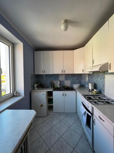 a kitchen with white cabinets and a stove top oven at Smak PRL-u in Ustka