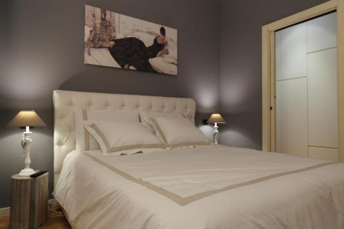ヴェローナにあるResidenza Città Anticaのベッドルーム(白い大型ベッド、ランプ2つ付)
