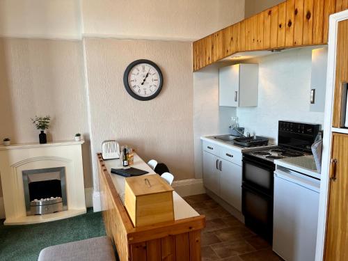 a kitchen with a clock on the wall at Capstone View in Ilfracombe