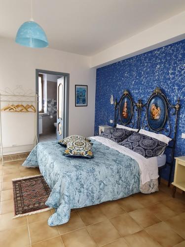 1 dormitorio con 1 cama grande y pared azul en La Castellana, en Civita