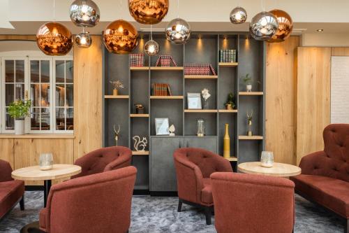 a restaurant with red chairs and tables and lights at Biohotel Leutascherhof in Leutasch