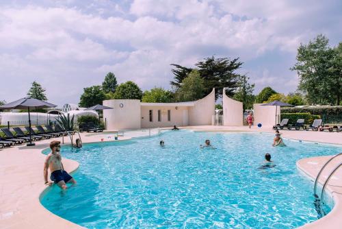 un groupe de personnes nageant dans une piscine dans l'établissement Villages Clubs du Soleil - BEG MEIL, à Fouesnant