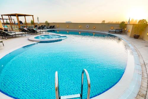 uma grande piscina em cima de um hotel em Elite Byblos Hotel no Dubai