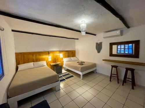 a bedroom with two beds and a table and stool at MIO Tulum Hotel Boutique in Tulum