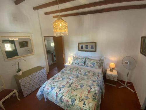 a bedroom with a bed and a chandelier at Casa do Vale in Sao Pedro de Tomar