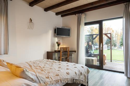 een slaapkamer met een bed en een tv aan de muur bij Resort U Fořta in Hřensko