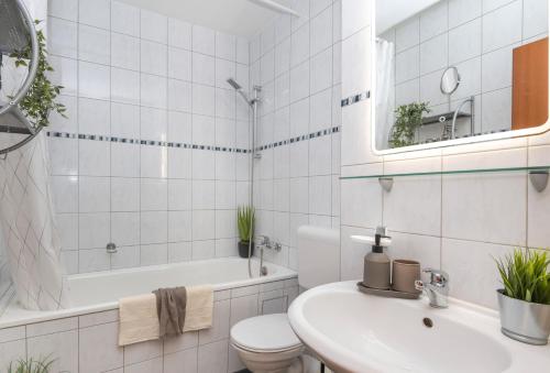 ein weißes Badezimmer mit einem Waschbecken, einer Badewanne und einem WC in der Unterkunft Kurzzeitglück 24h Self Check-In MG01 in Mönchengladbach