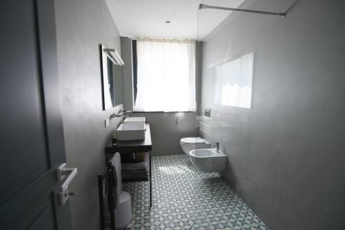 a white bathroom with a toilet and a sink at Villa al Cio, Bonassola in Bonassola