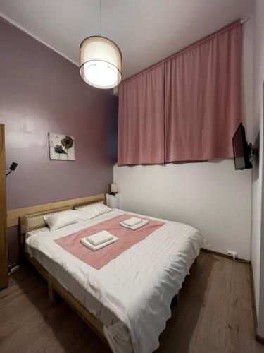 a bedroom with a large bed with a pink curtain at Mira Duo Room in Braşov