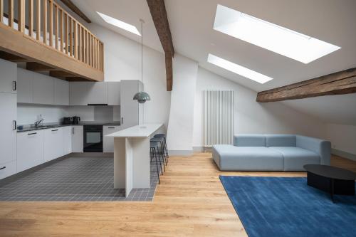 uma sala de estar com um sofá azul e uma cozinha em La Sauvage em Fribourg