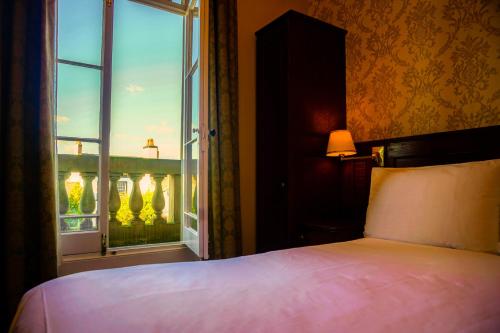 a bedroom with a bed and a window with a view at Manor House Hotel, Cockermouth in Cockermouth