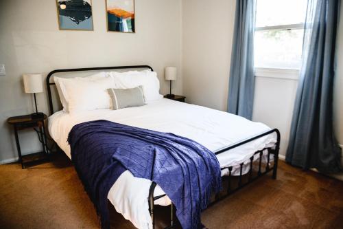 a bedroom with a bed with a blue blanket on it at Urban Cottage: Homey & Convenient in Huntington