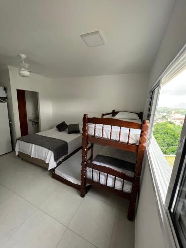 - une chambre avec 2 lits superposés et une fenêtre dans l'établissement Estúdio Canção Nova Condomínio da Fé, à Cachoeira Paulista