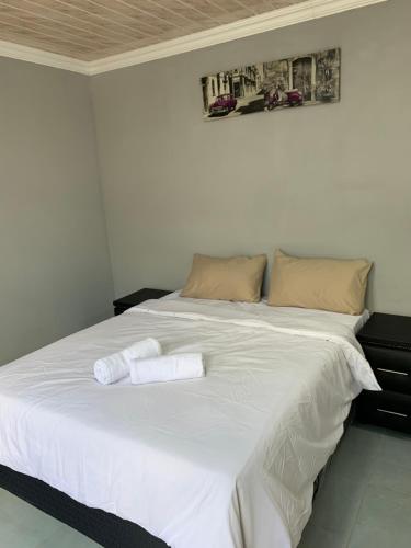 a large white bed with two towels on it at northmead lodge in Benoni