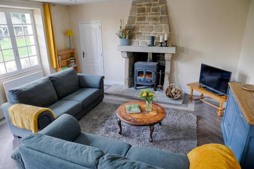 a living room with a couch and a fireplace at FORET TOTEM - Hébergements nature et bien-être en pleine forêt in Persquen