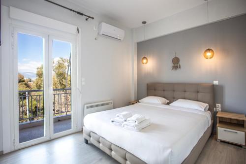 ein Schlafzimmer mit einem großen weißen Bett und einem Balkon in der Unterkunft GK Grand Comfort in Athen