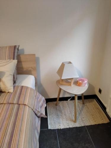 a bedroom with two beds and a table with a lamp at 'Nulle Part Ailleurs' in Dinant