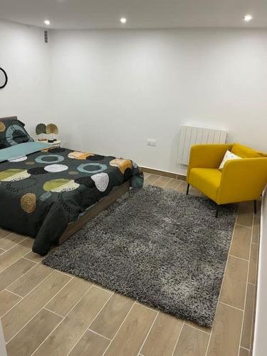 - une chambre avec un lit, une chaise jaune et un tapis dans l'établissement Logement neuf à 25mn DisneyLand et Paris Est, à Thorigny-sur-Marne