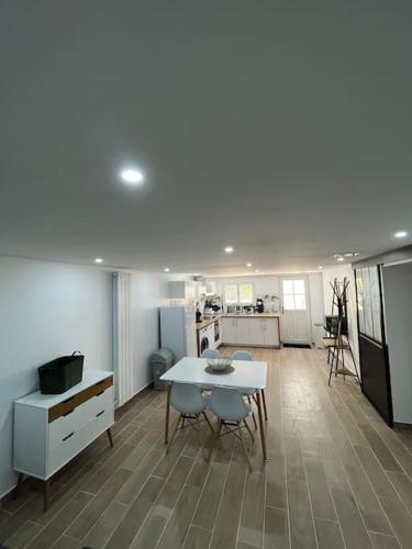 un salon avec une table et une cuisine dans l'établissement Logement neuf à 25mn DisneyLand et Paris Est, à Thorigny-sur-Marne