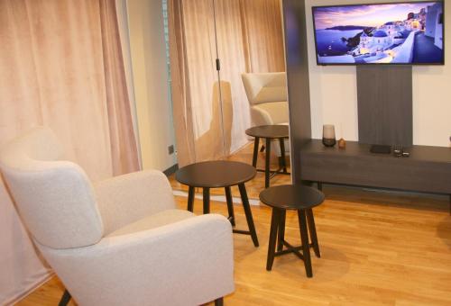 sala de estar con sillas, mesas y TV de pantalla plana en Falcon Apartment Center 2 Metro Złote Tarasy, en Varsovia
