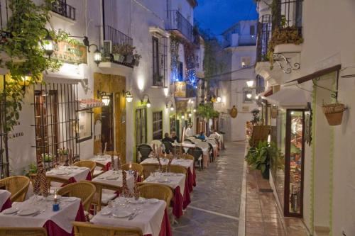 ein Restaurant mit Tischen und Stühlen in der Nacht auf einer Straße in der Unterkunft Marbella Center Apartment in Marbella