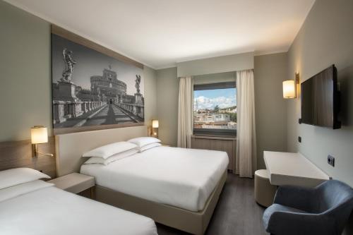 Pokój hotelowy z 2 łóżkami, krzesłem i oknem w obiekcie Hotel Marc'Aurelio w Rzymie